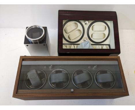 Three watch display cases to include a wooden example with a glass hinged lid, another example with a hinged lid, both with r