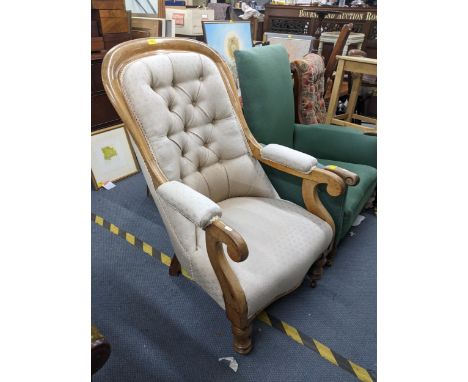A Victorian oak framed armchair with cream upholstery, button back with part upholstered arms, raised on bulbous legs and cas