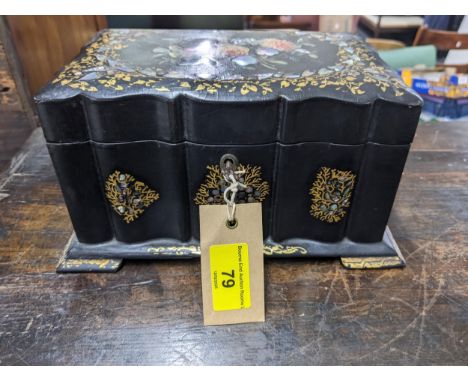 A Victorian papier mache lidded tea caddy revealing a double lidded compartment, decorated with floral designs, inlaid with a