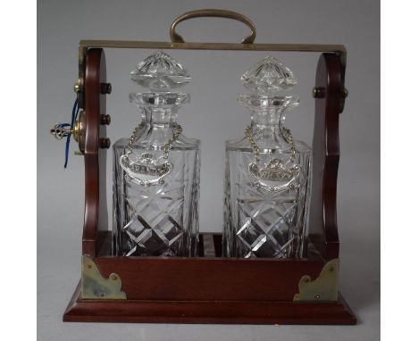 A Reproduction Silver Plate Mounted Two Bottle Tantalus with Whisky and Brandy Decanter Labels Complete with Key, 30cm wide 