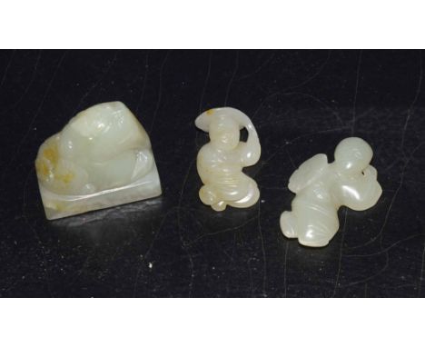 Group of three green jade pieces including a seal with a mythical beast carving, and two small jade carvings of figures (3)