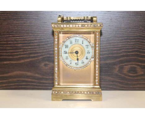 EARLY 20TH CENTURY CONTINENTAL BRASS CARRIAGE TIMEPIECE
with paste gem set face, supports and dial with white enamel chapter 