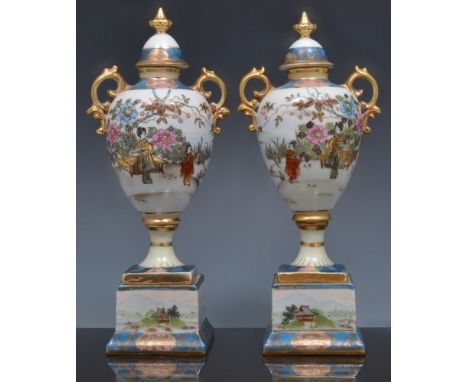 Pair of Noritake amphora shape cupboard vases, decorated with flowers and river landscapes, square plinths, 24cm and a Norita