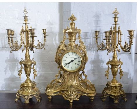 Cast brass three piece clock garniture, balloon shape clock case with a urn finial, scrolls and foliage, enamel dial signed I