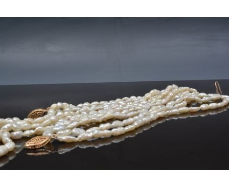 Pearl three strand necklace, a yellow metal clip and a matching bracelet.
