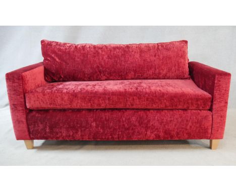 A contemporary two seater sofa in crushed velour upholstery on tapering block supports. H.75 L.178 D.84cm 