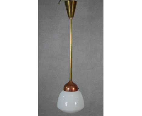 A vintage brass and copper ceiling light pendant with milk glass shade. L.82.5cm 