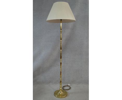 A brass standard lamp on turned column and circular platform base. H.170cm 
