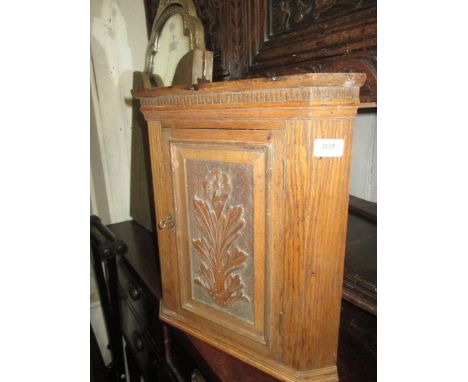 Small oak hanging corner cabinet with floral carved panel door