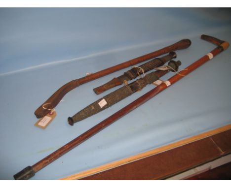 Two West African daggers, a leather covered truncheon and a silver mounted walking stick