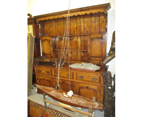 Good quality reproduction oak dresser with a boarded shelf back having two panelled doors and two small drawers above three d