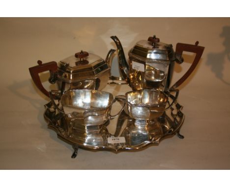 Silver plated four piece tea service on a plated scallop edged tray on low supports