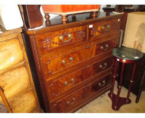 Edwardian mahogany chest of two short over three long drawers carved with swags and bows with brass handles raised on bracket