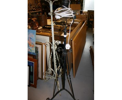 Green painted wrought iron oil standard lamp base together with a black wrought iron standard lamp with glass reservoir