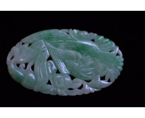 Small carved and pierced oval pale green jade panel decorated with exotic birds