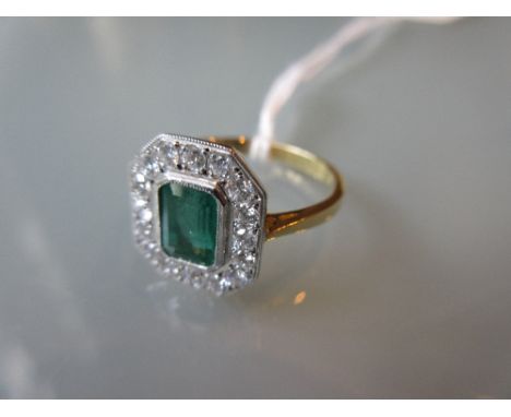 Art Deco style emerald and diamond ring of irregular octagonal form with a large central emerald and diamond surround