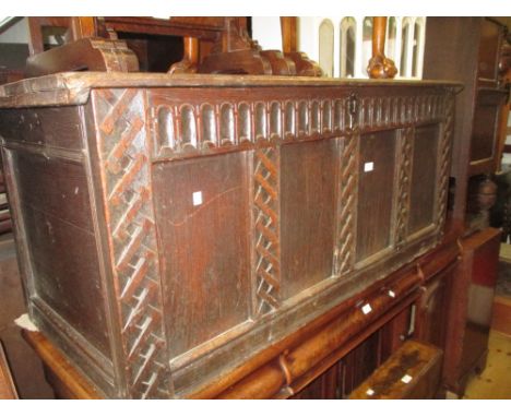 18th Century oak coffer, the plank top above a four panel front flanked by trellis carvings