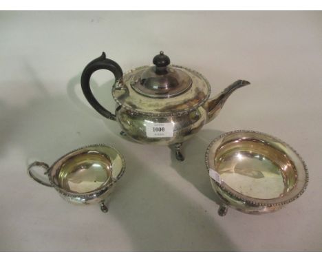 London silver circular three piece tea service on low hoof supports with ebonised handles