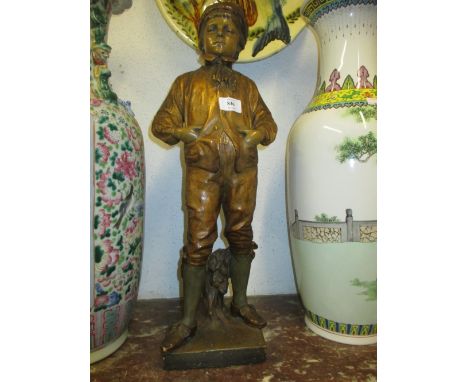 Goldscheider painted and gilded terracotta figure of a boy standing before a tree stump on a plinth base, impressed and mould