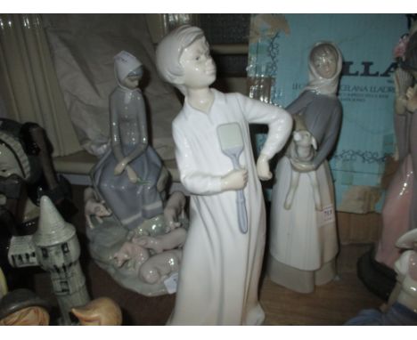 Lladro figure of a girl holding a lamb and a Nao figure of a boy in a nightdress