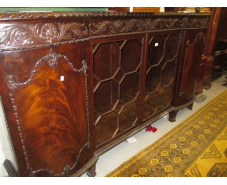 Early 20th Century mahogany inverted bow front side cabinet, the gadroon carved top above a floral frieze and pair of bar gla