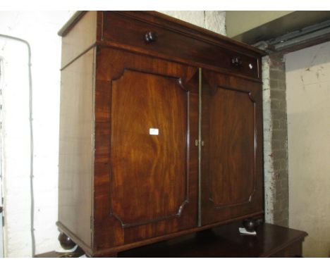 19th Century mahogany side cabinet having single long drawer with knob handles, above two panel doors raised on turned bun su