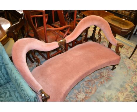 Victorian carved walnut and upholstered double spoon back sofa raised on cabriole front supports with brass and ceramic caste