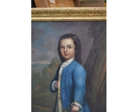 18th Century English school, oil on canvas, three quarter length portrait of a young boy standing before a landscape wearing 