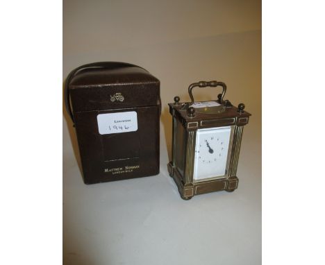 Small brass cased carriage clock by Matthew Norman, the enamel dial with Arabic numerals complete with a leather travel case