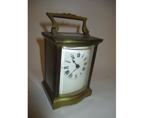 Brass cased carriage clock with serpentine front, enamel dial and Roman numerals with a single train movement