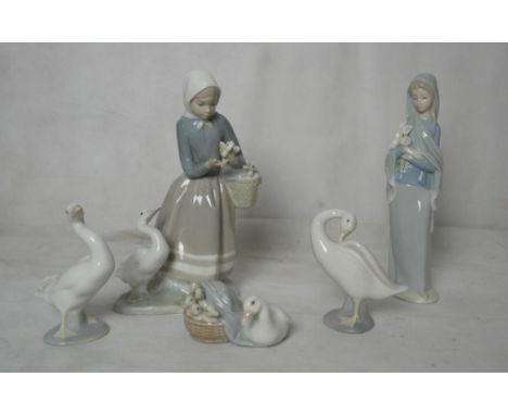 Three Lladro figures: girl with cat; girl with hat and flowers and girl with basket of puppies