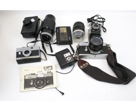 An assortment of vintage camera equipment and accessories. Including a Canon TLb with a 50mm lens, a Halina disc 200 camera, 