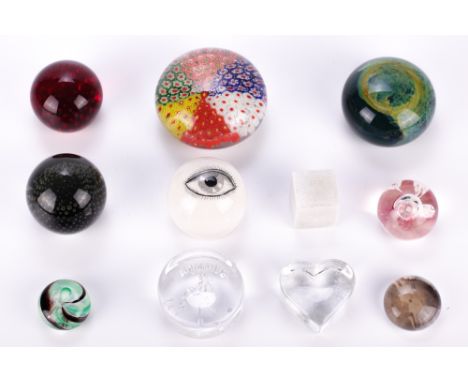 A collection of eleven assorted paperweights. Including nine glass, in various colours and designs; together with a resin cub