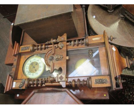 An early 20th century stained frame and walnut Vienna wall clock having crest, mask and spindle top on half turned column tru