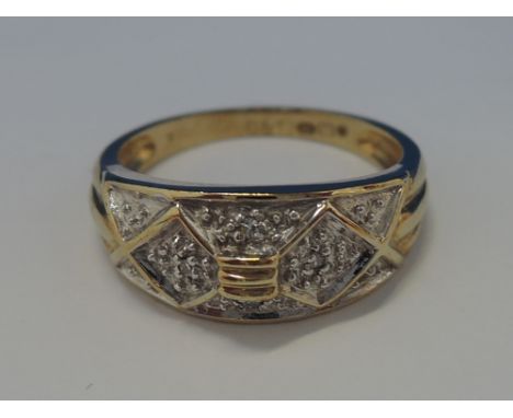 A ladies dress ring of band form having four diamond chips in a false mount with grid decoration on a 9ct gold loop