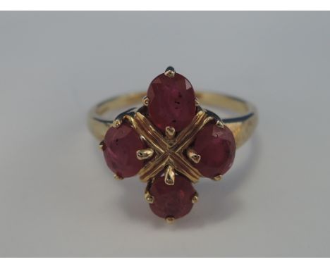 A ladies dress ring having four oval rubies in a claw set collared mount on a 9ct gold loop