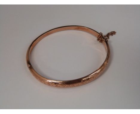 A Victorian 9ct rose gold hinged bangle having scroll and cross decoration, Chester hallmarks