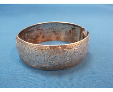 A silver hinged bangle having scroll decoration and inscription to inside, Birmingham 1939