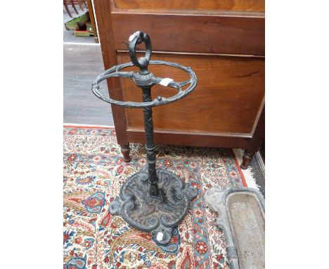 A black cast iron stick stand of traditional style having circular top