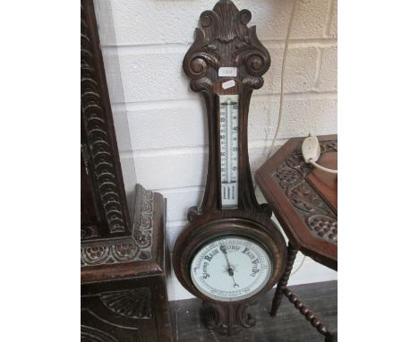 An Edwardian oak banjo barometer having thermometer and aneroid scale