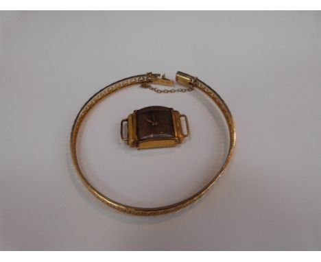 A yellow metal bangle stamped 585 having pierced key style decoration (af) and a ladies yellow metal wrist watch stamped 18K 