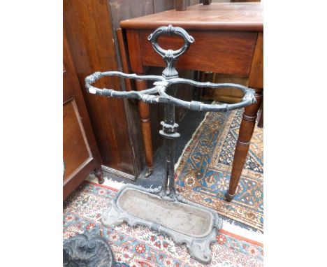 A black cast iron stick stand of traditional style having two division top 