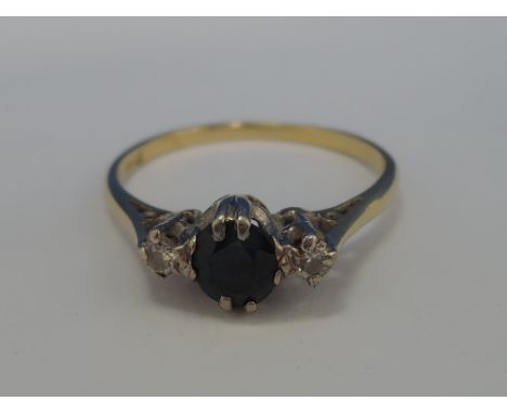 A ladies three stone sapphire and diamond dress ring having a raised claw setting and open shoulders on a yellow metal loop s