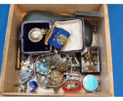 A wooden box containing a selection of vintage costume jewellery including brooches, collar studs, cufflinks, white metal ban