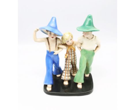 Goldscheider - a 1930s pottery figural group modelled as two young boys, both wearing pointed hats, striding along arm in arm