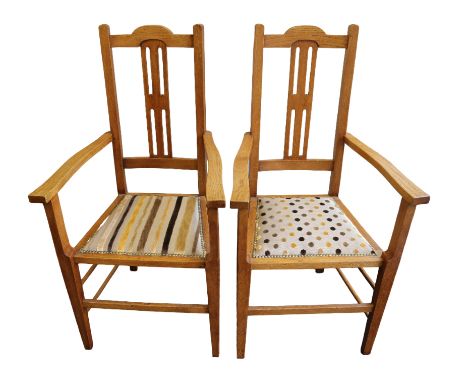 A pair of Arts & Crafts (c.1910) light oak dining chairs, both having central rectangular stylised ladder back, cylindrical s