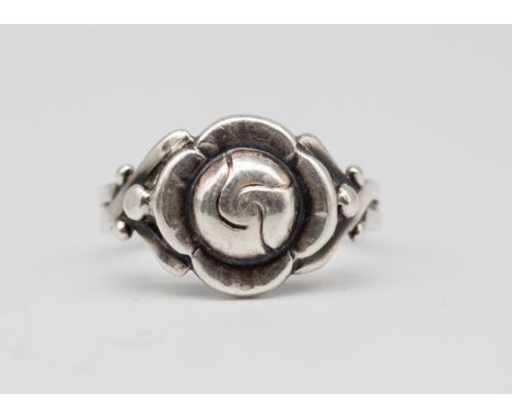 Georg Jensen - A stylish mid-century Danish silver ring, with intricate crossed shank and central flower, circa 1940s/50s. Ma