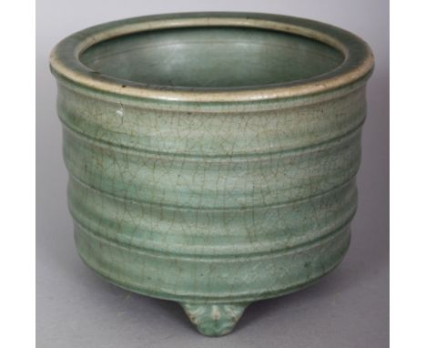 A CHINESE LONGQUAN CELADON STONEWARE TRIPOD CENSER, possibly Ming Dynasty, the sides ribbed, the base unglazed, 5.75in wide a