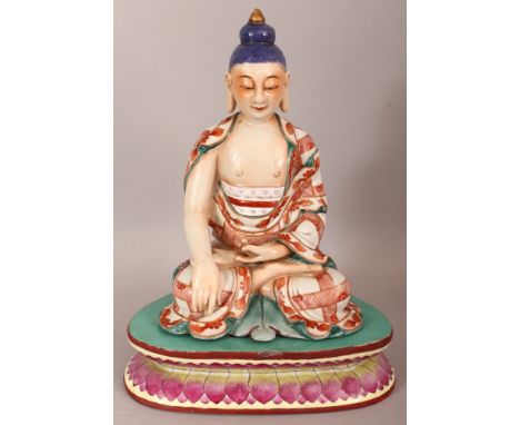 AN UNUSUAL CHINESE ENAMEL DECORATED PORCELAIN FIGURE OF BUDDHA, together with a rounded triangular famille rose stand, the Bu