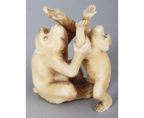 A JAPANESE MEIJI PERIOD IVORY OKIMONO OF TWO PLAYING MONKEYS, unsigned, the fur naturalistically rendered, 2.75in high.